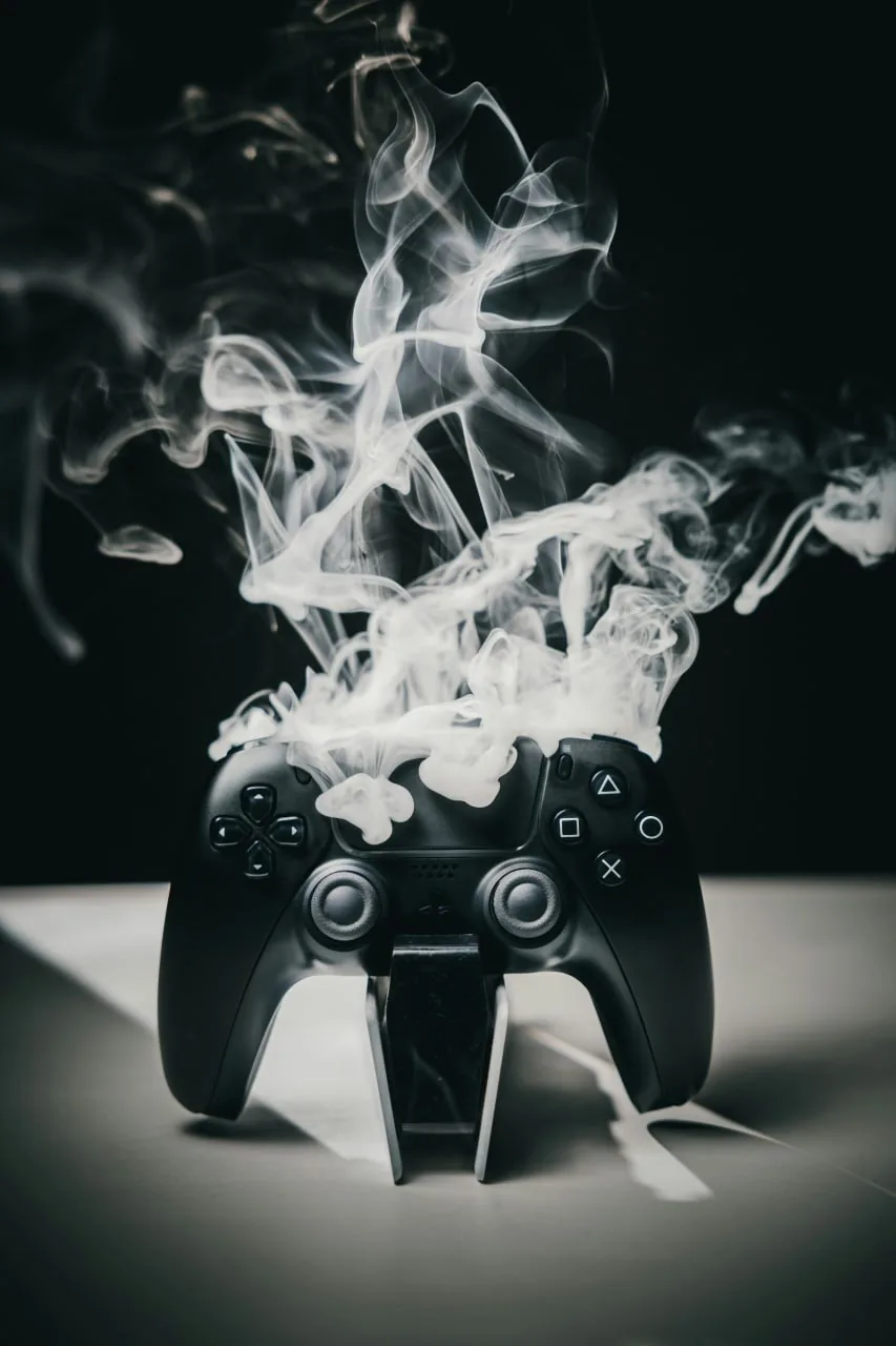 Black game controller with rising smoke, symbolizing high-intensity gameplay and performance-focused game launch marketing