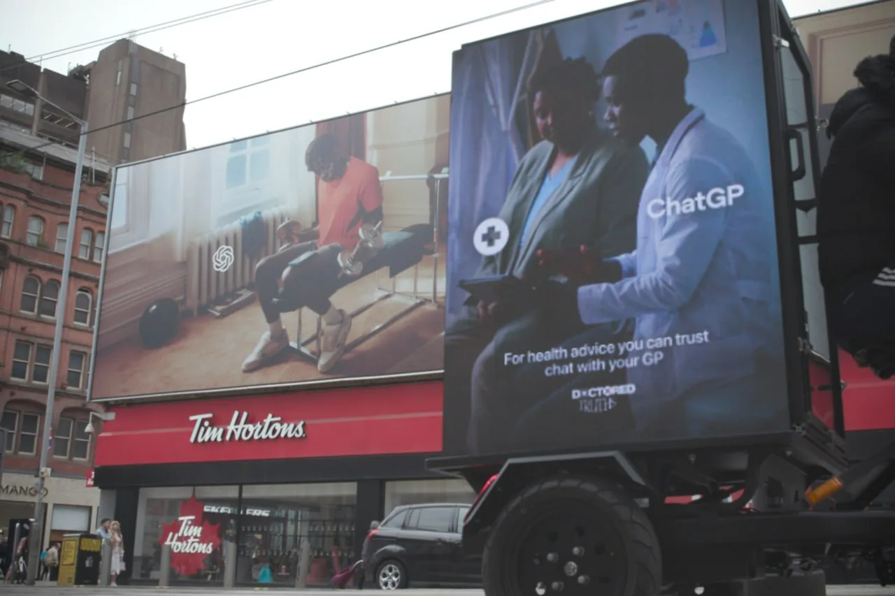 Billboard truck with medical consultation ad driving past a Tim Hortons on a busy city street