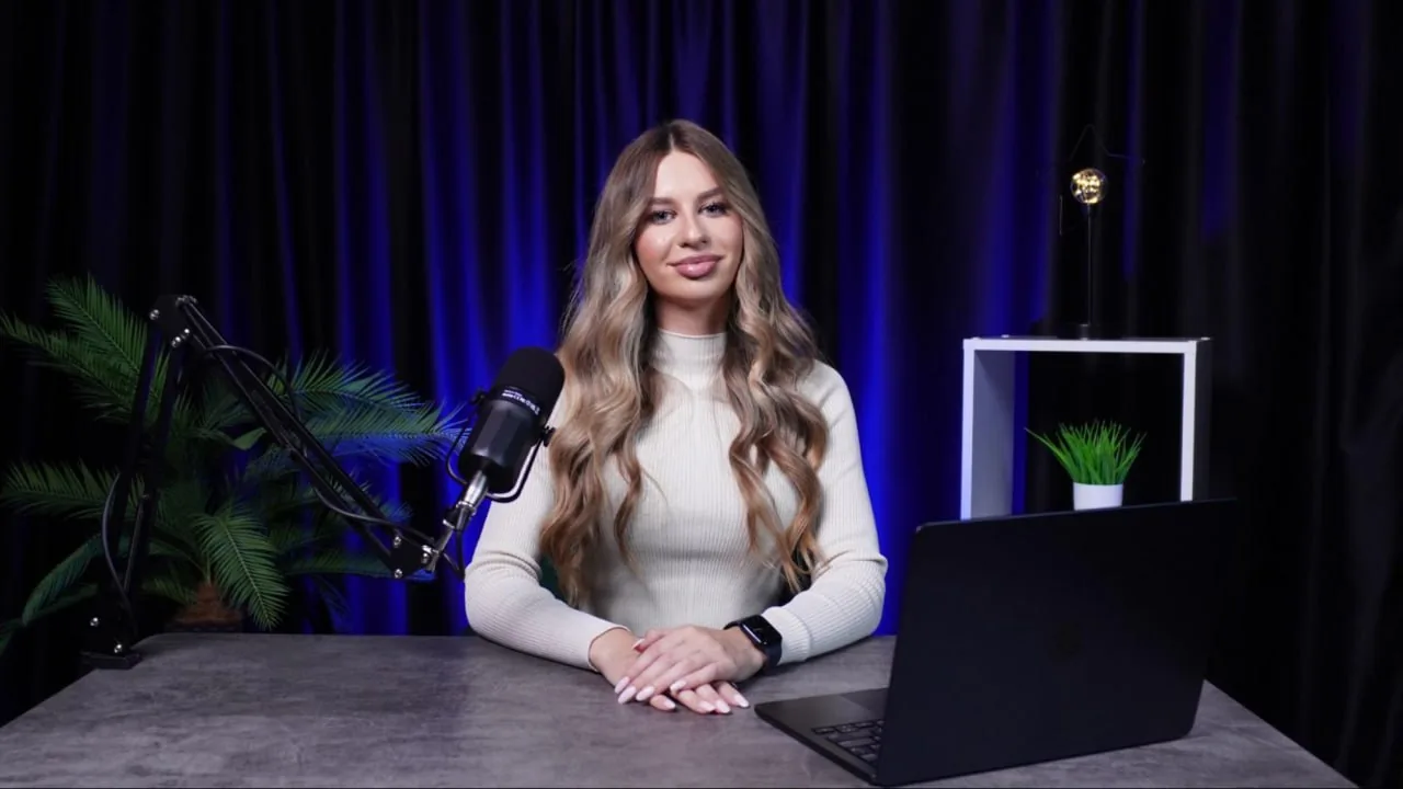 Woman at desk with microphone and laptop in a studio workspace