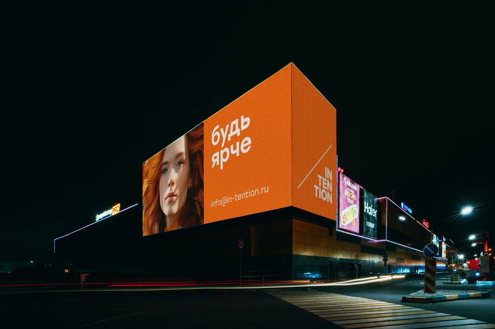 Night city street with a large illuminated billboard above a building